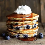To make fluffy pancakes, gather these items: - 1 cup all-purpose flour - 1 tablespoon sugar - 1 tablespoon baking powder - ½ teaspoon salt - 1 cup milk (preferably whole) - 1 large egg - 2 tablespoons unsalted butter, melted - 1 teaspoon vanilla extract - 1 cup fresh blueberries (or frozen, thawed) - Additional butter or oil for cooking - Maple syrup and whipped cream for serving (optional) These ingredients work together to create a soft and light texture. Measuring your ingredients correctly is key for fluffy pancakes. Here are some tips: - Use a dry measuring cup for flour. Spoon the flour into the cup and level it off with a knife. - For liquids, use a clear measuring cup. Check the measurement at eye level. - Use a kitchen scale for precision, especially for flour. One cup usually weighs about 120 grams. Accurate measurements help create the right pancake texture. For the best flavor, choose high-quality ingredients: - Use fresh baking powder. Old powder may not rise well. - Whole milk adds creaminess. Low-fat milk can make pancakes tougher. - Select ripe, juicy blueberries. They should be firm, not mushy. Quality ingredients truly enhance the taste of your pancakes. For the full recipe, check above. To make fluffy pancakes, start by gathering your ingredients. You will need: - 1 cup all-purpose flour - 1 tablespoon sugar - 1 tablespoon baking powder - ½ teaspoon salt - 1 cup milk (preferably whole) - 1 large egg - 2 tablespoons unsalted butter, melted - 1 teaspoon vanilla extract - 1 cup fresh blueberries (or frozen, thawed) - Additional butter or oil for cooking - Maple syrup and whipped cream for serving (optional) In a large bowl, whisk the flour, sugar, baking powder, and salt. Mix until these dry items blend well. In another bowl, combine the milk, egg, melted butter, and vanilla extract. Stir until it is smooth. Next, pour the wet mix into the dry mix. Stir gently, but do not overmix. It is okay if the batter has a few lumps. Finally, fold in the blueberries. Make sure they spread evenly in the batter. Once your batter is ready, heat a non-stick skillet or griddle over medium heat. Lightly grease the surface with butter or oil. For each pancake, pour about ¼ cup of batter onto the skillet. Cook the pancake until bubbles form on the surface, and the edges look set. This should take about 2 to 3 minutes. When it’s ready, flip the pancake with a spatula. Cook for another 1 to 2 minutes until it turns golden brown. If you see any remaining batter, repeat the cooking steps, adding more butter or oil as needed. Flipping pancakes can be tricky. Wait until you see those bubbles before you flip. This shows the pancake is ready. Use a wide spatula to make it easier. To serve, stack the pancakes on a plate. Drizzle with maple syrup and add whipped cream if you like. Enjoy your fluffy pancakes with blueberries that burst with flavor. For a complete guide, check the full recipe. To make your pancakes extra fluffy, use fresh baking powder. Old baking powder can lead to flat pancakes. Mix the dry ingredients well before adding wet ones. This helps create air pockets. When you mix the wet and dry ingredients, stir gently. Overmixing can make the pancakes tough. Leave some lumps in the batter; they are okay. Let the batter rest for a few minutes before cooking. This allows the flour to hydrate fully. A common mistake is not measuring ingredients correctly. Use dry and wet measuring cups for best results. Another mistake is cooking on too high heat. Medium heat works best to cook pancakes evenly. If you flip too soon, the pancakes might fall apart. Wait for bubbles to form on the surface. Lastly, don’t overcrowd the skillet. Cook a few pancakes at a time to ensure even cooking. Serve your fluffy pancakes warm with maple syrup. A dollop of whipped cream adds a nice touch. Fresh berries on top can add color and flavor. You can also sprinkle powdered sugar for a sweet finish. If you want something unique, try a scoop of yogurt. For a fun twist, add chocolate chips or nuts in the batter. Enjoy these pancakes with a side of bacon or sausage for a hearty meal. For the full recipe, check the section above. {{image_2}} If you need to change the recipe, it's easy. For gluten-free pancakes, use gluten-free flour. You can also swap milk for almond or oat milk. If you want to avoid sugar, use a sugar substitute like stevia. For a vegan option, replace the egg with a mashed banana or unsweetened applesauce. These swaps keep your pancakes tasty and fluffy. While blueberries are delicious, you can try other fruits too. Chopped bananas, strawberries, or raspberries work great. You might also add chocolate chips for a sweet touch. Nuts, like walnuts or pecans, can add a nice crunch. Just remember to adjust the amount to keep the batter thick and fluffy. Seasonal flavors can make pancakes even more fun. In fall, add pumpkin puree and spices like cinnamon. For winter, try crushed peppermint or a hint of nutmeg. In spring, mix in fresh lemon zest for a bright taste. Summer is perfect for peaches or nectarines. These variations keep breakfast exciting all year long. For the full recipe, refer to the Fluffy Blueberry Pancakes section. To store leftover pancakes, first let them cool. Place them in a single layer on a plate. Once cool, stack them between parchment paper in an airtight container. This keeps them fresh and prevents sticking. Store the container in the fridge for up to three days. When you’re ready to enjoy your pancakes again, reheat them for the best taste. You can use a microwave or a skillet. For the microwave, place one pancake on a plate. Heat for 20-30 seconds. If you use a skillet, warm it over medium heat. Add a little butter and cook each side for about one minute. This makes them warm and fluffy again. Freezing pancakes is a great way to save time. Start by letting them cool completely. Then, place them in a single layer on a baking sheet. Freeze them for about two hours. Once they are frozen, stack them in a freezer bag. Remove as much air as possible before sealing. You can freeze them for up to two months. To reheat, follow the same instructions as before. Enjoy your fluffy pancakes anytime! For the full recipe, check the details above. Pancakes get their fluffiness from a few key things. First, baking powder adds air to the batter. This makes the pancakes rise when they cook. Second, mixing the batter gently helps keep air in. If you overmix, the pancakes can turn flat. Lastly, using a bit of milk adds moisture. This helps create steam, which makes the pancakes puff up as they cook. Yes, you can use frozen blueberries. Just make sure to thaw them first. Drain any extra water to keep the batter from getting too wet. Frozen blueberries can still taste great in your pancakes. They may bleed a bit, turning the batter blue. But this can add a fun twist to your fluffy pancakes! You can make pancakes without eggs by using substitutes. Some good options include mashed banana or unsweetened applesauce. Use about ¼ cup of either for each egg. You can also try a mixture of water, oil, and baking powder. This will help bind the batter together. Just remember, pancakes may not be as fluffy without eggs, but they can still be tasty! For a full recipe, check out the *Fluffy Blueberry Pancakes*. Fluffy pancakes start with the right ingredients and careful steps. Quality matters for the best taste. Follow the preparation and cooking tips to achieve the perfect texture. Remember to avoid common pitfalls that can ruin your pancakes. You can also try different flavors and dietary swaps. Store any extras properly so you can enjoy breakfast quickly later. With these tips, you’ll create delicious pancakes every time. Enjoy the process and make it a fun family meal!
