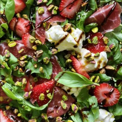 - Mixed Baby Greens: Use 4 cups of mixed baby greens, like arugula, spinach, and watercress. These greens offer a fresh base for the salad. They add texture and flavor, making each bite exciting. - Fresh Strawberries: Select 1 cup of fresh strawberries. Look for ripe, juicy berries. Hull and slice them before adding. The sweetness of strawberries pairs perfectly with the saltiness of prosciutto. - Burrata Cheese: Choose 1 ball of burrata cheese. This cheese should feel soft and creamy. Cut it into large pieces to showcase its rich inside. Handle it gently to keep its beautiful shape. - Prosciutto: Use 6 slices of high-quality prosciutto. Look for thinly sliced meat with a nice marbling. Tear it into bite-sized pieces for easy eating. The savory flavor complements the salad well. - Roasted Pistachios: Prepare 1/4 cup of roasted pistachios, roughly chopped. These nuts add a nice crunch. You can substitute them with almonds or walnuts if you prefer. - Dressing Ingredients: Use 2 tablespoons of balsamic glaze and 2 tablespoons of extra virgin olive oil. These dressings enhance the salad's flavor. Add salt and freshly cracked black pepper to taste for extra seasoning. For the full recipe, check out the details above. 1. In a large mixing bowl, take the mixed baby greens and sliced strawberries. Gently toss them together until they blend well. This step ensures every bite has a mix of flavors. 2. Next, drizzle the extra virgin olive oil over the salad mixture. Add some salt and freshly cracked black pepper. Toss lightly again to coat everything evenly. This adds a nice flavor boost. 3. For presentation, grab a large serving platter or individual plates. Artfully arrange the salad mixture on the platter. Create a little nest in the center for the burrata pieces. 4. Now, scatter the torn prosciutto pieces on top of the salad. This adds a savory touch that pairs perfectly with the sweetness of the strawberries. 5. Place the burrata pieces on the salad. Make sure they stand out, as they are the stars of the dish. 6. Drizzle balsamic glaze over the entire salad. This will add sweetness and depth, making every bite more delightful. 7. Finish off by sprinkling the roasted pistachios on top. They give a nice crunch. Add fresh basil leaves to garnish, giving the salad a vibrant look. - Serve the salad immediately to keep the greens fresh. The bright colors and flavors are best enjoyed right away. - You can plate the salad in elegant dishes for a special touch. Consider adding a drizzle of extra balsamic glaze around the platter. This enhances the visual appeal. - This salad works great as a light lunch or appetizer. You can pair it with crusty bread or a light white wine for a complete meal. For a detailed view of this recipe, check out the Full Recipe. To keep your greens fresh, wash them in cold water. Dry them well using a salad spinner or clean kitchen towel. Store them in a container with a paper towel inside to absorb moisture. This helps them stay crisp longer. For strawberries, it’s best to keep them in the fridge. Don't wash them until you're ready to eat. Store them in a breathable container, like a berry basket. This allows air to circulate and keeps them fresh. Burrata cheese needs careful handling. Keep it in its liquid until you are ready to use it. Store it in the fridge and consume it within a few days for the best taste and texture. To give your salad a gourmet look, use a large, shallow bowl. Arrange the greens and strawberries in a colorful pattern. Place burrata pieces in the center for a stunning focal point. You can impress guests by serving the salad on individual plates. Drizzle extra balsamic glaze around the plate for a fancy touch. Scatter the pistachios on top for added flair and crunch. Fresh basil leaves add a pop of color, making your dish even more appealing. {{image_2}} You can change the burrata cheese if you want. Try using fresh mozzarella or goat cheese. These swap outs still give you a creamy feel. They also add a nice twist to the flavor. When it comes to greens, you have options. Instead of mixed baby greens, use kale or romaine. Both add crunch and taste. You can even mix them for a more interesting salad. Spinach also works and is mild in flavor. Want to add some extra fruit? Peaches or figs work great. They add sweetness and a juicy bite. You can slice them thin and toss them in. If you want to switch up the dressing, try honey mustard or lemon vinaigrette. These dressings give a different flavor profile. They can brighten the dish without overpowering it. For more ideas, check out the Full Recipe. It offers tips and tricks to make this salad your own! To keep your Prosciutto Strawberry Burrata Salad fresh, store it properly. I recommend using an airtight container. This helps keep the flavors vibrant. Try to eat it within two days for the best taste. Store the salad without the dressing. Dressings can make greens soggy. If you have extra strawberries or burrata, keep them in separate containers. This way, they stay fresh longer. If your greens start to wilt, don't worry. You can refresh them! Rinse the greens gently in cold water. Pat them dry with a towel. This will help them regain some crunch. You can also reuse the salad components in other dishes. Toss leftover greens into a wrap or sandwich. Use the burrata as a topping for pasta or pizza. It’s all about being creative with your leftovers! To make a vegetarian version, simply leave out the prosciutto. You can replace it with a flavorful option like roasted chickpeas or marinated artichokes. Both add texture and taste. You can use the same ingredients and follow the recipe steps. This way, you keep the salad fresh and vibrant. Yes, you can prepare parts of the salad in advance. Wash and dry the greens, and store them in a sealed container. Slice the strawberries and keep them in the fridge. However, wait to add the burrata and prosciutto until serving. This keeps the salad fresh and tasty. Burrata cheese offers several health benefits. It is rich in calcium, which helps your bones. It also has protein, which is good for muscle growth. Moreover, burrata contains healthy fats, which can support heart health. Enjoy it in moderation for a tasty treat! For the full recipe, check out the detailed instructions above. This blog post covered how to make a delicious Prosciutto Strawberry Burrata Salad. You learned the best ingredients to use, their preparation, and tips for storage. I shared serving suggestions and variations to keep things fresh. Remember, using quality ingredients makes a big difference. Try different fruits or greens to find your perfect mix. Enjoy your salad and impress your guests with these easy steps.