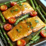 - 4 salmon fillets (about 6 oz each) - ¼ cup pure maple syrup - 2 tablespoons soy sauce - 1 tablespoon Dijon mustard - 1 tablespoon olive oil - 2 cups asparagus, trimmed - 2 cups cherry tomatoes, halved - 2 cloves garlic, minced - Salt and pepper to taste - Fresh parsley, chopped (for garnish) When cooking, quality matters. Choose fresh, wild-caught salmon for the best flavor. Look for bright, firm fillets. The skin should be shiny and moist. For veggies, select vibrant asparagus and ripe cherry tomatoes. Fresh herbs, like parsley, add a nice touch. Always use pure maple syrup, not the flavored kind. It enhances the glaze’s taste. You can swap salmon for another fish, like trout or cod. If you want a meatless option, try tofu instead. Use tamari if you need a gluten-free soy sauce. Dijon mustard can be replaced with whole grain mustard or honey mustard. For a lower-carb option, skip the glaze or use a sugar-free alternative. The veggies can change too. Try zucchini or bell peppers if you like. First, I set my oven to 400°F (200°C). This heat gives the salmon a nice cook. While it heats, I gather all my ingredients. I measure out ¼ cup of pure maple syrup, 2 tablespoons of soy sauce, and 1 tablespoon of Dijon mustard. I also grab 1 tablespoon of olive oil. Next, I rinse 4 salmon fillets and place them on a baking sheet lined with parchment paper. I season them with salt and pepper. In a small bowl, I whisk together the maple syrup, soy sauce, Dijon mustard, and olive oil. I make sure to blend them well. The glaze smells sweet and tangy. I save half of this glaze for later. This way, I can drizzle it over the dish before serving. Now, I prepare the veggies. In a separate bowl, I toss 2 cups of trimmed asparagus and 2 cups of halved cherry tomatoes with 2 minced garlic cloves, salt, and pepper. I spread these veggies around the salmon on the baking sheet. I then brush each salmon fillet with the maple glaze. Once everything is on the baking sheet, I place it in the oven. I bake for about 12-15 minutes. I check for doneness by seeing if the salmon flakes easily with a fork. The veggies should look bright and tender. For a nice finish, I can broil the salmon and veggies for 2 minutes at the end. This adds a lovely caramelized look. Finally, I drizzle the reserved glaze over the salmon and veggies and garnish with fresh chopped parsley. To cook salmon perfectly, start with fresh fillets. Look for bright, moist flesh. The fillets should smell like the sea, not fishy. Preheat your oven to 400°F (200°C) for even cooking. Season the salmon with salt and pepper before applying the glaze. This will add a nice touch to the final flavor. Brush the salmon with the maple glaze generously. Bake it for 12 to 15 minutes. The salmon is done when it flakes easily with a fork. If you want a caramelized finish, broil it for the last two minutes. Fresh vegetables make a big difference in taste. For asparagus, look for bright green stalks. They should be firm, not limp. When choosing cherry tomatoes, pick ones that are shiny and firm. Avoid any with wrinkles or dark spots. Always buy seasonal veggies for the best flavor. This dish uses asparagus and cherry tomatoes, but feel free to mix in other fresh veggies you enjoy. Washing them before cooking keeps them clean and crisp. Herbs and spices can elevate your dish. Fresh parsley adds a pop of color and flavor. You can also try dill or basil for a different twist. Garlic is a must in this recipe, giving it depth. If you like heat, add a pinch of red pepper flakes. Remember to taste your glaze before cooking. Adjust sweetness or saltiness to match your preference. Simple tweaks, like adding lemon zest, can brighten the dish. {{image_2}} You can swap salmon for chicken or tofu. For chicken, use boneless, skinless breasts. The cooking time may change to about 20-25 minutes. For tofu, use firm or extra-firm types. Cut them into thick slices and marinate them in the glaze for about 15 minutes before cooking. The sweet glaze works well with both options, giving a rich flavor. Feel free to change the veggies. Broccoli, bell peppers, and zucchini work great. You can also try green beans or snap peas. Just remember to keep the cooking times similar. Each choice brings a unique taste and texture to the dish. Adding citrus can brighten the dish. Try squeezing fresh lemon or lime juice over the salmon and veggies. You can also add orange zest to the glaze. This extra layer of flavor pairs well with maple syrup. It makes the dish even more refreshing and delicious. After your meal, let the salmon and veggies cool first. Place leftovers in an airtight container. You can keep them in the fridge for up to three days. Make sure to store the glaze separately if you have any left. This helps keep everything fresh. To reheat, preheat your oven to 350°F (175°C). Place the salmon and veggies on a baking sheet. Cover them with foil to avoid drying out. Heat for about 10-12 minutes. If you like it crispy, you can broil them for the last two minutes. Always check the center to ensure it’s warm. If you want to freeze your leftovers, make sure they are completely cool. Wrap the salmon and veggies tightly in plastic wrap. Then, place them in a freezer-safe bag or container. They can last up to three months in the freezer. When you are ready to eat, thaw them in the fridge overnight before reheating. Yes, you can use salmon fillets with skin. The skin helps keep the fish moist and adds flavor. Cooking with the skin on can also make it easier to handle the fillets. When ready to serve, you can simply remove the skin if you prefer. Maple glazed salmon pairs well with many sides. Here are some great options: - Rice or quinoa for a hearty base. - Mashed potatoes or sweet potatoes for creaminess. - Fresh salad with greens and a light dressing. - Roasted or steamed vegetables like broccoli or carrots add color and nutrition. The salmon is done when it flakes easily with a fork. You can also check the internal temperature. It should reach 145°F (63°C). The flesh should look opaque and have a nice pink color. If you see this, it’s ready to enjoy! Cooking with the right ingredients is key to tasty meals. I shared steps to make maple-glazed salmon, including prep, glaze, and cooking techniques. Use fresh veggies and herbs to enhance flavors. You can also try variations with chicken or tofu. Store your leftovers well for quick meals later. For any questions, like how to tell when your salmon is done, refer to the FAQs. Enjoy your cooking journey and share your results!