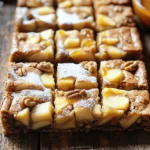 To make Brown Butter Apple Blondies, gather these ingredients: - ½ cup unsalted butter - 1 cup brown sugar, packed - ½ cup granulated sugar - 2 large eggs - 1 teaspoon vanilla extract - 1 ¾ cups all-purpose flour - 1 teaspoon baking powder - ½ teaspoon baking soda - ½ teaspoon salt - 1 teaspoon ground cinnamon - 1 medium sweet apple, like Honeycrisp or Fuji, peeled, cored, and diced - ½ cup chopped walnuts (optional) You can swap out some ingredients if needed: - For butter, use ghee or coconut oil for a dairy-free option. - Instead of brown sugar, try coconut sugar or honey for a different sweetness. Want to mix things up? Here are some fun add-ins: - Use different nuts, like pecans or almonds, for crunch. - Add chocolate chips for a sweet twist. - Try dried fruits, such as cranberries or raisins, for extra flavor. Start by prepping your apple and nuts. Choose a sweet apple like Honeycrisp or Fuji. Peel, core, and dice it into small pieces. If you like nuts, chop your walnuts now. This adds a nice crunch. Next, melt your butter in a medium saucepan over medium heat. Watch it closely. Stir often until the butter turns a golden brown color and smells nutty. This takes about 5 to 7 minutes. Be careful not to burn it; burnt butter can ruin the flavor. In a mixing bowl, pour the brown butter. Whisk in the brown sugar and granulated sugar until smooth. Then, add the eggs one at a time. Mix well after each egg. Stir in the vanilla extract for a nice flavor boost. In another bowl, mix the flour, baking powder, baking soda, salt, and ground cinnamon. Gradually add this dry mix to the wet ingredients. Stir until just combined. Do not overmix, or your blondies may turn out dense. Fold in your diced apple and chopped walnuts if you're using them. Make sure they are evenly spread throughout the batter. Prepare your baking pan by lining it with parchment paper. Leave some paper hanging over the edges. This helps you lift out the blondies later. Preheat your oven to 350°F (175°C). Pour the batter into the prepared pan. Smooth the top with a spatula. Bake for 25 to 30 minutes. You will know they are done when a toothpick inserted in the center comes out clean, with a few moist crumbs. Let the blondies cool in the pan for about 10 minutes. Use the parchment to lift them out. Transfer them to a wire rack to cool completely. Then, cut into squares and enjoy! To make brown butter, heat unsalted butter in a medium pan. Stir it often and watch closely. The butter should turn a deep golden brown. It will smell nutty and fragrant. This takes about 5-7 minutes. If it burns, start over. Look for small brown bits at the bottom. This shows the butter is ready. To check if the blondies are done, use a toothpick. Stick it into the center. If it comes out clean or with a few moist crumbs, they are ready. Let them cool in the pan for ten minutes. This helps them set better. Cutting them too soon can make them fall apart. For a fun touch, dust cooled blondies with powdered sugar. You can also serve them with vanilla ice cream or drizzle caramel sauce on top. This adds extra flavor and makes them look pretty! Serve them warm for a cozy treat, or at room temperature for a nice snack. {{image_2}} You can make your Brown Butter Apple Blondies even more tasty! Adding spices like nutmeg or maple extract can boost the flavor. These small changes will make a big difference. Try different apples too. A tart Granny Smith can give a nice contrast to the sweet batter. Honeycrisp apples add a juicy sweetness that blends well with brown butter. If you need gluten-free blondies, swap all-purpose flour for a gluten-free blend. Just check that the blend works well in baking. For a vegan version, use coconut oil instead of butter and flax eggs in place of regular eggs. A flax egg is one tablespoon of flaxseed meal mixed with three tablespoons of water. Let it sit for a few minutes to thicken. Serve your blondies warm for a cozy treat. They go great with vanilla ice cream melting on top. For a chilled option, let them cool completely. Dust them with powdered sugar for an elegant touch. If you're hosting a party, cut them into smaller squares. You can even drizzle caramel sauce over them for a sweet twist! To keep your Brown Butter Apple Blondies fresh, use an airtight container. Store them at room temperature if you plan to eat them in a few days. For longer storage, the fridge works well too. Just make sure they are completely cool before sealing them up. If you want to save some blondies for later, freezing is a great option. Wrap each blondie in plastic wrap and then place them in a freezer bag. This keeps them fresh and prevents freezer burn. When you're ready to enjoy them, take them out and let them thaw in the fridge overnight. You can also warm them in the microwave for a few seconds to restore that fresh-baked taste. At room temperature, your blondies will stay good for about three days. If you store them in the fridge, they can last up to a week. Just remember, the longer they sit, the less fresh they may taste. Always check for any changes in texture or smell before enjoying your treats! Yes, you can use other apples. I recommend Honeycrisp or Fuji for their sweetness. Granny Smith adds tartness, which can balance the sugar. Braeburn apples offer a nice blend of sweet and tart flavors. Each apple type gives a unique taste and texture to the blondies. To check for doneness, look for a golden brown top. Insert a toothpick in the center; it should come out clean or with a few moist crumbs. If the toothpick has wet batter on it, the blondies need more time. The edges should pull away from the pan slightly. You can make these blondies ahead of time. Bake and cool them, then store in an airtight container. They stay fresh for up to three days at room temperature. For longer storage, wrap them well and freeze. Thaw at room temperature when ready to enjoy. These Brown Butter Apple Blondies blend rich flavors and textures. We covered all key ingredients, including varieties of apples and sugar. I showed you how to prep and mix the batter for perfect results. Remember to experiment with add-ins and flavors that excite you. Store your blondies properly, and they’ll last longer. The tips provided ensure a successful bake every time. Enjoy making your delicious blondies, whether warm or chilled. Happy baking!