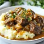 - 2 pounds beef stew meat - 1 onion, diced - 3 cloves garlic, minced - 1 cup beef broth - 1 cup cream of mushroom soup - 2 tablespoons Worcestershire sauce - 2 teaspoons dried thyme - 1 teaspoon paprika - Salt and pepper to taste - 4 tablespoons cornstarch - ¼ cup water In this recipe, the beef stew meat forms the heart of the dish. I use 2 pounds of tender beef. I cut it into 1-inch cubes for even cooking. The onion adds sweetness and depth. Dice it well to blend into the dish. I also add 3 cloves of minced garlic for a robust flavor. For the sauce, I choose 1 cup of beef broth. This gives a rich base. I add 1 cup of cream of mushroom soup. It brings creaminess and umami. Worcestershire sauce adds a tangy kick with just 2 tablespoons. For seasoning, I use dried thyme and paprika. Each adds its own unique touch. I sprinkle salt and pepper to taste, so you can adjust it as needed. To thicken the gravy, I mix 4 tablespoons of cornstarch with ¼ cup of water. This slurry gives the sauce a nice consistency. Gather these ingredients and get ready for a hearty dinner delight! {{ingredient_image_1}} Searing the beef First, heat a large skillet over medium-high heat. Add one tablespoon of olive oil. Once hot, add 2 pounds of beef stew meat. Sear the beef for about 5 to 7 minutes. Make sure to brown all sides. This step gives the beef a rich flavor. After browning, transfer the beef to the crock pot. Sautéing aromatics In the same skillet, add 1 diced onion and 3 minced garlic cloves. Sauté for 2 to 3 minutes. Cook until the onions look soft and slightly clear. This adds a nice depth of flavor to the dish. Creating the sauce In a bowl, mix together 1 cup of beef broth, 1 cup of cream of mushroom soup, and 2 tablespoons of Worcestershire sauce. Add 2 teaspoons of dried thyme, 1 teaspoon of paprika, salt, and pepper to taste. Stir well. Pour this mixture over the seared beef in the crock pot. Cooking the beef tips Cover the crock pot. Cook on low for 6 to 8 hours or on high for 3 to 4 hours. The beef should become tender during this time. Thickening the gravy In the last 30 minutes, mix 4 tablespoons of cornstarch with ¼ cup of water. This creates a slurry. Stir the slurry into the gravy in the crock pot. This will help thicken the sauce nicely. Final touches before serving Once the beef is tender, taste the gravy. Adjust seasonings if needed. Stir gently to coat the beef in the thick gravy. You are now ready to serve your hearty dish! Why is searing important? Searing beef adds a rich flavor and color. It locks in juices, making your beef tender. This step helps create a mouthwatering crust, making each bite more enjoyable. If you're short on time, skip searing. You can place the raw beef directly in the Crock Pot. It will still cook well, but you miss the deep flavors that searing brings. To elevate your dish, consider adding more seasonings. You might try garlic powder, onion powder, or even black pepper. Each will add depth to the gravy. Always taste during cooking. Adjust seasonings as needed. If you find it needs a little more kick, add some hot sauce or red pepper flakes. Remember, it's all about personal taste. What should you serve with beef tips and gravy? Mashed potatoes or rice are great choices. They soak up the tasty gravy perfectly. You could also try egg noodles or polenta for something different. Present your meal nicely by garnishing with fresh parsley. Even a sprinkle of black pepper can add a nice touch. Creating a beautiful plate makes your meal feel special. Pro Tips Pat the Beef Dry: Before searing, make sure to pat the beef cubes dry with paper towels. This helps achieve a better sear, enhancing the flavor. Use Quality Beef Broth: Opt for a low-sodium beef broth or homemade broth for a richer flavor. This will elevate the overall taste of your gravy. Add Vegetables: Consider adding carrots or mushrooms to the crock pot for additional flavor and nutrition. They complement the beef perfectly. Let it Rest: After cooking, let the beef tips rest for about 10 minutes before serving. This allows the juices to redistribute for a more tender bite. {{image_2}} If you want to switch things up, consider using different cuts of beef. Chuck roast is a great choice if you can't find stew meat. It is tender and full of flavor. You can also try using venison for a unique twist. For those who need a dairy-free option, use a dairy-free cream of mushroom soup. You can find many brands that offer this. Alternatively, you can make your own by blending sautéed mushrooms with coconut milk. If you prefer using an Instant Pot, you can cook this dish much quicker. Sear the beef as usual, then add all ingredients. Cook on high pressure for about 35 minutes. Let the pressure release naturally for best results. For stovetop cooking, use a heavy pot. Cook the beef on medium heat for about 1-1.5 hours. Keep an eye on it, and stir often to prevent sticking. Adjust the cooking time based on how tender you like your beef. Different slow cooker models may have varying heat levels. If your slow cooker runs hot, check the beef after 4 hours on low. You want it tender but not overcooked. You can easily change up the flavor of your beef tips. For an Asian-inspired twist, add soy sauce, ginger, and sesame oil. You can also throw in some broccoli or bell peppers for extra color and taste. If you like bold flavors, try adding cumin, chili powder, or smoked paprika for a Southwestern flair. You can even toss in some black beans and corn for a full meal. Each variation allows you to make this dish your own while keeping it delicious. Enjoy experimenting with these ideas! To store leftovers in the fridge, let the beef tips cool. Place the beef and gravy in an airtight container. This keeps the dish fresh and tasty. You can store it for up to three days. If you want to enjoy it later, remember to label the container with the date. For freezing portions, use freezer-safe bags or containers. Make sure to remove as much air as possible. This helps prevent freezer burn. You can freeze the beef tips for up to three months. When you’re ready to eat, thaw it in the fridge overnight before reheating. You can reheat beef tips on the stovetop or in the microwave. On the stovetop, heat it gently over low heat. Stir often to keep it from sticking. In the microwave, use a microwave-safe dish and cover it loosely. Heat in short bursts to avoid overcooking. To keep the flavor and texture, add a splash of beef broth if it seems dry. Enjoy your delicious meal! Cooking beef tips in a Crock Pot takes about 6-8 hours on low and 3-4 hours on high. The low setting gives a more tender result since the beef cooks slowly. If you are short on time, the high setting can work too. Yes, you can skip searing the beef. However, searing adds a nice flavor and color. When you sear, you lock in the juices. The meat also develops a deeper taste. If you don't sear, the dish may taste milder. You can serve beef tips and gravy with many sides. Traditional options include mashed potatoes or rice. These absorb the gravy well. For a twist, try egg noodles or bread. You can also add a side of steamed veggies or a fresh salad for balance. This blog post offers a guide to making delicious beef tips and gravy. We covered key ingredients, including beef stew meat, broth, and seasonings. The step-by-step instructions detail preparation and cooking methods. I shared helpful tips for enhancing flavor and variations to try. Additionally, I provided storage advice to keep leftovers fresh. In the end, exploring this recipe can bring warmth and flavor to your meals. Enjoy the process and make it your own!