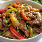 To make Chinese Pepper Steak with Onions, gather these fresh items: - 1 lb flank steak, sliced thinly against the grain - 2 tablespoons soy sauce - 1 tablespoon cornstarch - 1 tablespoon sesame oil - 1 bell pepper (red or green), sliced thinly - 1 large onion, thinly sliced - 3 cloves garlic, minced - 1 teaspoon ginger, minced - 1 tablespoon oyster sauce - 1 teaspoon black pepper - 2 tablespoons vegetable oil - Green onions, chopped (for garnish) If you can't find an ingredient, here are some swaps: - Flank steak can be replaced with sirloin or skirt steak. - Soy sauce can be swapped for tamari for a gluten-free option. - Sesame oil may be replaced with olive oil if needed. - Bell peppers can be any color, or you can use snow peas for a crunch. - Oyster sauce can be omitted or replaced with soy sauce for a lighter flavor. Using fresh ingredients makes a big difference in flavor. Here's what to look for: - Choose flank steak that is bright red with a bit of marbling. - Pick bell peppers that are firm and shiny with no blemishes. - Select onions that are heavy for their size with dry, papery skins. - Fresh garlic should be firm and plump, while ginger should be smooth and unblemished. - Always check the expiration dates on sauces and oils for the best taste. {{ingredient_image_1}} First, take your flank steak and slice it thinly. Cutting against the grain helps it stay tender. Place the sliced steak in a bowl. Add 2 tablespoons of soy sauce and 1 tablespoon of cornstarch. Mix well so all the pieces get coated. Let it marinate for about 15 to 20 minutes. This step adds flavor and helps tenderize the meat. Next, heat 1 tablespoon of sesame oil in a large skillet or wok over medium-high heat. Once hot, add the marinated steak. Spread it out in a single layer. Let it sear for 2 to 3 minutes until it turns brown. This step locks in the juices and gives a nice flavor. After browning, remove the steak from the skillet and set it aside. In the same skillet, add 2 tablespoons of vegetable oil. Once the oil is hot, toss in the sliced onions and bell pepper. Add 3 cloves of minced garlic and 1 teaspoon of minced ginger. Sauté these for 4 to 5 minutes. You want the veggies to become tender but still crisp. This stage adds color and texture to your dish. Now, it’s time to bring everything together. Return the cooked steak to the skillet with the veggies. Pour in 1 tablespoon of oyster sauce and sprinkle 1 teaspoon of black pepper. Stir-fry for another 2 minutes. This ensures the steak is cooked through and the sauce coats everything well. Once done, remove it from the heat and garnish with chopped green onions. Enjoy your delicious Chinese pepper steak with onions! To get the best steak, choose flank steak. Slice it thinly against the grain. This makes the meat tender. Marinate it for at least 15 minutes. Use soy sauce and cornstarch in your marinade. The cornstarch helps keep the steak juicy. When cooking, make sure the skillet is hot. Sear the steak for 2-3 minutes. Don't overcrowd the pan; this helps it brown nicely. Add depth to your dish by using fresh ingredients. Minced garlic and ginger bring great taste. Using sesame oil gives a nice nutty flavor. For more umami, oyster sauce is a must. Feel free to mix in other veggies, like carrots or snap peas. A splash of vinegar can brighten the dish too. Don't forget to finish with chopped green onions for freshness. One mistake is not marinating long enough. This can lead to bland steak. Another error is cooking the steak too long. Overcooked meat becomes tough. Make sure to use high heat when searing. Avoid using too much oil; it can make the dish greasy. Lastly, don't skip the green onions. They add color and flavor to your meal. Pro Tips Marinate for Flavor: Allow the steak to marinate for at least 20 minutes to enhance the flavor and tenderness of the meat. High Heat for Searing: Ensure your skillet or wok is hot enough before adding the steak; this will help achieve a nice sear and lock in the juices. Veggie Crunch: Don’t overcook the vegetables; they should remain slightly crisp for the best texture and flavor contrast with the beef. Garnish for Freshness: Finish the dish with freshly chopped green onions; they add a pop of color and a fresh flavor that brightens the meal. {{image_2}} You can easily change the protein in this dish. Instead of flank steak, you can use chicken, pork, or shrimp. Each protein will bring its own flavor and texture. - Chicken: Use boneless, skinless chicken breast, cut into thin strips. Marinate it just like the steak. - Pork: Thinly slice pork tenderloin. It cooks fast and gets tender quickly. - Shrimp: Use peeled, deveined shrimp. Add them to the skillet last, cooking just until pink. If you want a meat-free meal, there are great veggie options. Tofu is a perfect choice. - Tofu: Use firm tofu for a hearty texture. Press it to remove extra moisture, then cut into cubes. Marinate like steak and follow the same cooking steps. - Mushrooms: Try using a mix of shiitake and button mushrooms for depth of flavor. Sauté them until tender. - Seitan: This wheat-based protein has a chewy texture. Slice it thin and treat it like meat in the recipe. You can adjust the flavors in this dish to fit your taste. - Spicy: Add sliced jalapeños or a dash of chili flakes for heat. - Sweet: Mix in a splash of honey or add some sliced carrots for natural sweetness. - Herbs: Fresh cilantro or basil can add a fresh touch. Sprinkle them on top just before serving. These variations keep the dish fun and exciting for everyone at your table. After you cook your Chinese pepper steak, let it cool down. Place it in an airtight container. This keeps it fresh. Store it in the fridge for up to three days. Make sure to eat it within this time for the best taste. To reheat, you can use a microwave or a skillet. If using a microwave, place the steak in a bowl. Cover it with a lid or a damp paper towel. Heat on medium power for 1-2 minutes. Stir halfway through. If using a skillet, heat it on medium heat. Add a splash of water or oil to keep it moist. Stir until it's hot. This helps keep the flavors intact. You can freeze your pepper steak if you want to save some for later. Allow it to cool completely. Place it in a freezer-safe bag or container. Squeeze out any air before sealing. It can stay in the freezer for up to three months. When ready to eat, thaw it in the fridge overnight before reheating. This keeps the taste fresh and delicious. You can serve this dish with plain white rice or fried rice. The rice soaks up the sauce well. You might also enjoy it with steamed broccoli or sautéed bok choy. If you want something different, try serving it with noodles. This adds a nice twist and extra flavor. To make this dish gluten-free, use tamari instead of soy sauce. Tamari is a great substitute that still provides the same salty flavor. You should also check your oyster sauce for gluten. Some brands offer gluten-free options. Always read the label to be sure. Yes, you can make this dish ahead of time. Cook the steak and vegetables, then cool them down. Store them in the fridge for up to three days. When you’re ready to eat, just reheat it in a skillet. This saves you time on busy days and still tastes great! This blog post covered the key steps to make Chinese Pepper Steak with Onions. We discussed ingredients, marinating and cooking methods, and tips for a perfect dish. I shared ways to customize your recipe and how to store leftovers. Remember, using fresh ingredients and avoiding common mistakes boosts flavor. Whether you're a beginner or experienced cook, you can impress with this dish. Enjoy your cooking journey and make it your own!