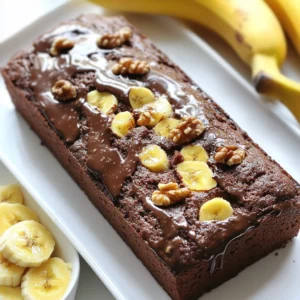 To make a great chocolate banana bread, gather these key ingredients: - 3 ripe bananas, mashed - 1/2 cup unsweetened cocoa powder - 1/2 cup granulated sugar - 1/4 cup brown sugar, packed - 1/3 cup melted coconut oil - 2 large eggs - 1 teaspoon vanilla extract - 1 teaspoon baking soda - 1/2 teaspoon salt - 1 1/2 cups all-purpose flour - 1/2 cup semi-sweet chocolate chips These ingredients work together to create a moist and rich bread. The ripe bananas add natural sweetness. Cocoa powder brings in the chocolate flavor. Coconut oil keeps the bread tender. You can customize your chocolate banana bread with these mix-ins and toppings: - 1/4 cup chopped walnuts (optional) - 1/4 cup chopped pecans - 1/4 cup dried fruit like raisins or cranberries - A sprinkle of sea salt on top Adding walnuts or pecans gives a nice crunch. Dried fruit can add a sweet twist. A sprinkle of salt can enhance the chocolate flavor. If you need to swap some ingredients, here are some good substitutes: - Coconut oil: Use vegetable oil or melted butter. - Granulated sugar: Brown sugar or coconut sugar can work. - All-purpose flour: Use whole wheat flour or oat flour for a different taste. These substitutes can change the flavor or texture a bit. Always remember to adjust cooking times if needed. {{ingredient_image_1}} First, you must prepare your loaf pan. Preheat your oven to 350°F (175°C). Grease a 9x5-inch loaf pan with a little oil. You can also line it with parchment paper. This will help the bread come out easily after baking. Make sure the pan is ready before you mix your batter. Next, grab a large mixing bowl. Add three ripe bananas that you have mashed. They should be soft and sweet. Then, pour in 1/3 cup of melted coconut oil. This oil will add moisture and a nice flavor. Now, add 1/2 cup of granulated sugar and 1/4 cup of packed brown sugar. Stir these ingredients together until they blend well. Crack in two large eggs and add 1 teaspoon of vanilla extract. Mix everything until smooth and well combined. Now, it’s time to add the dry ingredients. Sprinkle in 1/2 cup of unsweetened cocoa powder. This gives the bread its rich chocolate taste. Then, add 1 teaspoon of baking soda and 1/2 teaspoon of salt. Stir this mixture until you see no more dry bits. Gradually mix in 1 1/2 cups of all-purpose flour. Do not overmix; just until it is combined. Finally, fold in 1/2 cup of semi-sweet chocolate chips and, if you like, 1/4 cup of chopped walnuts. This will add extra flavor and texture. Pour the batter into the loaf pan and smooth the top. Bake for 55-60 minutes. Check with a toothpick; it should come out clean. Let it cool for 10 minutes before moving it to a wire rack. To get the best texture, use ripe bananas. Ripe bananas are soft and sweet. They help the bread stay moist. Mash them well, but not too smooth. A few small lumps add nice texture. Also, don’t overmix the batter. Stir until just combined. Overmixing can make the bread tough. Lastly, let the bread cool in the pan for a bit. This helps it set and gives it the right texture. Store your chocolate banana bread in an airtight container. This keeps it moist and fresh. If you have a lot left, slice it first. Place parchment paper between slices for easy access. You can keep it at room temperature for up to three days. If you want to store it longer, freeze it. Wrap it tightly in plastic wrap and then in foil. It can last up to three months in the freezer. One common mistake is not measuring ingredients correctly. Use a kitchen scale or measuring cups for accuracy. Another mistake is skipping the cooling time. Cutting into the bread too soon can make it fall apart. Also, check your oven temperature. An oven that is too hot can burn the outside while leaving the inside raw. Lastly, don’t forget to check for doneness. Use a toothpick to test if the center is cooked through. Pro Tips Use Overripe Bananas: The riper the bananas, the sweeter and more flavorful your bread will be. Look for bananas with brown spots for the best results. Don’t Overmix the Batter: To keep your bread light and fluffy, mix just until the flour is incorporated. Overmixing can lead to a dense texture. Experiment with Add-Ins: Feel free to customize your bread with other mix-ins like shredded coconut, dried fruit, or different nuts for a unique twist. Check for Doneness: Ovens can vary, so check your bread a few minutes before the end of the baking time. It’s done when a toothpick inserted in the center comes out clean. {{image_2}} You can make a gluten-free version of this bread. Use gluten-free flour instead of all-purpose flour. Look for blends that work well in baking. Make sure to check the ingredients on the package. Some blends contain xanthan gum, which helps with texture. This bread will still taste rich and moist. To make this bread vegan, swap the eggs for flax eggs. Mix one tablespoon of flaxseed meal with three tablespoons of water. Let it sit for five minutes to thicken. Replace coconut oil with applesauce for moisture. Use dairy-free chocolate chips for a fully vegan treat. This will give you a tasty, plant-based dessert. You can add extra flavors to your chocolate banana bread. Try adding spices like cinnamon or nutmeg for warmth. A splash of almond extract can add a lovely twist. You can also mix in different nuts or dried fruits. This will give your bread unique tastes and textures. Each variation can make your bread special and fun! To keep your Chocolate Banana Bread fresh, wrap it tightly in plastic wrap or foil. Place it in an airtight container. This method keeps it moist for up to four days. Store it at room temperature, away from sunlight. If you live in a humid area, refrigerate it to prevent spoilage. To freeze Chocolate Banana Bread, first, let it cool completely. Then, slice the bread for easy serving. Wrap each slice in plastic wrap, then in aluminum foil. Place the wrapped slices in a freezer bag. This way, you can enjoy a slice anytime. It can last in the freezer for about three months. To reheat your Chocolate Banana Bread, remove it from the fridge or freezer. If frozen, let it thaw in the fridge overnight. For the best taste, warm slices in a toaster or oven. Heat at 350°F (175°C) for about 10 minutes. This brings back its soft, moist texture and rich flavor. Enjoy your warm treat! Yes, you can make this bread without eggs. Use mashed bananas or applesauce instead. About 1/4 cup of either works well. This keeps the bread moist. The taste will stay great too. You can also try flaxseed meal. Mix 1 tablespoon of flaxseed with 2.5 tablespoons of water. Let it sit until it thickens. This mix acts like an egg in the recipe. To make the bread less sweet, reduce the sugars. Use only 1/4 cup of granulated sugar. You can skip the brown sugar too. The ripe bananas add natural sweetness. If you want a richer chocolate flavor, add more cocoa powder. This will balance the sweetness and give a deeper taste. If your bread is too dense, it might be overmixed. Mix the batter just until combined. Avoid stirring too much. Check your baking soda too. It should be fresh. Old baking soda won't help the bread rise. Lastly, make sure you measure flour correctly. Too much flour can cause density. Spoon flour into your measuring cup, then level it off. You learned the key ingredients for making chocolate banana bread. I shared tips for mixing, baking, and storing it. You can even try gluten-free or vegan options. Avoid common mistakes to get the best texture. In the end, you can enjoy this bread in many ways. Remember to store and reheat it properly for the best taste. Get creative with flavors, and have fun baking!