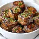 To make Garlic Butter Steak Bites, gather these key ingredients: - 1 lb sirloin steak, cut into 1-inch cubes - 4 tablespoons unsalted butter - 4 cloves garlic, minced - 1 tablespoon fresh rosemary, minced (or 1 teaspoon dried) - 1 tablespoon fresh thyme, minced (or 1 teaspoon dried) - Salt and pepper to taste - Fresh parsley, chopped for garnish These ingredients create a tasty dish that is easy to cook. The sirloin steak gives a nice texture. The butter and garlic add rich flavor, while the herbs bring freshness. You can customize your Garlic Butter Steak Bites with a few add-ins: - A pinch of red pepper flakes for heat - A splash of Worcestershire sauce for depth - Sliced mushrooms for added texture These options can change the taste and make it your own. Feel free to mix and match based on your taste. While sirloin is great, you can also use other cuts: - Ribeye for more fat and flavor - Tenderloin for a leaner option - Flank steak for a different texture Each cut offers a unique bite. Choose based on your preference and budget. Enjoy crafting your perfect Garlic Butter Steak Bites! {{ingredient_image_1}} To start, pat the steak cubes dry with paper towels. This step is key. It helps the meat brown nicely. Next, season the steak cubes generously with salt and pepper on all sides. You want bold flavor in every bite. Now, your steak is ready for the skillet! Grab a large skillet and melt 2 tablespoons of butter over medium-high heat. Wait until it is hot and bubbling. Then, add the steak cubes in a single layer. Do not overcrowd the skillet. Sear the steak for about 2-3 minutes without moving them. This creates a nice crust. Flip the steak bites and sear the other side for another 2-3 minutes. Aim for medium-rare for the best taste. Once done, remove the steak bites and set them aside. In the same skillet, lower the heat to medium. Add the remaining 2 tablespoons of butter. Once it's melted, toss in the minced garlic, rosemary, and thyme. Stir for about 30 seconds until fragrant. This step fills your kitchen with a wonderful aroma. Now, return the steak bites to the skillet. Toss them in the garlic herb butter for 1-2 minutes. Make sure they are well coated. Finally, remove from heat, garnish with fresh parsley, and serve right away. Enjoy your tasty steak bites! To sear steak bites well, start with dry meat. Pat the cubes with paper towels. This step helps them brown nicely. Use a hot skillet. Heat it over medium-high heat. Add butter and let it melt until bubbly. Place the steak cubes in a single layer. Don’t overcrowd the pan. Give them space to sear. Cook for 2-3 minutes on one side. Flip them to brown the other side for another 2-3 minutes. This gives a great crust and keeps the inside juicy. A heavy skillet works best for searing. Cast iron or stainless steel pans hold heat well. They help form a nice crust. Avoid non-stick pans for this step. They can’t get hot enough for a good sear. If you have a grill pan, that’s great too. Just ensure it’s preheated before adding the steak. Seasoning is key to tasty steak bites. Start with salt and pepper. Sprinkle them generously on all sides. You can add more flavors too. Fresh herbs like rosemary and thyme bring great taste. If you like heat, try some red pepper flakes. Taste the garlic butter as you cook. Adjust seasonings to make it perfect for you. Remember, cooking is about your personal touch! Pro Tips Pat the Steak Dry: Ensuring the steak is dry before seasoning helps achieve a perfect sear and crust. Don't Overcrowd the Pan: Searing in batches allows for better browning and prevents steaming the meat. Let It Rest: After cooking, allow the steak bites to rest for a few minutes to retain their juices. Customize the Herbs: Feel free to experiment with different herbs like oregano or basil for unique flavor profiles. {{image_2}} For a kick, add red pepper flakes to the garlic butter. Start with ½ teaspoon and adjust to your taste. This spice enhances the flavor and gives the dish a nice heat. You can also mix in some sriracha or hot sauce. Toss the steak bites in the spicy butter for a bold twist. Want to change the flavor? Use different herbs! Try fresh basil or oregano instead of thyme and rosemary. Both add a lovely taste. You can also use a mix of dried herbs if fresh ones are not handy. This change will keep your steak bites fresh and exciting. For a Mediterranean flair, add some olives, sun-dried tomatoes, or feta cheese to the dish. After cooking, toss in these ingredients with the garlic butter. They will add saltiness and rich flavor. Serve with a side of tzatziki sauce for a refreshing dip. This variation will take you on a tasty trip to the Mediterranean coast. To keep your garlic butter steak bites fresh, store them in an airtight container. Let them cool to room temperature before sealing. This helps prevent moisture buildup. Place the container in the fridge if you plan to eat them within three days. When you're ready to enjoy your leftovers, reheating gently is key. Use a skillet over low heat for the best results. Add a small pat of butter to the pan. Heat the steak bites for about 3-5 minutes, stirring often. This keeps the meat juicy and tasty. You can also reheat them in the microwave. Use a microwave-safe dish and cover it with a damp paper towel. Heat for 30 seconds, then check. If you have extra steak bites, freezing is a great option. Place them in a freezer-safe bag or container. Make sure to remove as much air as possible before sealing. Label the bag with the date. You can freeze them for up to three months. When you're ready to eat, thaw in the fridge overnight. Reheat as mentioned above for the best taste. The best way to cook steak bites is by searing them in a hot skillet. Start with a well-heated pan. Use a good amount of butter for flavor. This method gives a nice crust while keeping the inside tender. Don't overcrowd the pan; cook in batches if needed. This way, each piece gets the right amount of heat. You can tell steak bites are done by checking their color and firmness. For medium-rare, look for a warm red center. You can also use a meat thermometer. It should read 130°F for medium-rare. If you want them more done, aim for 145°F for medium. Letting them rest for a few minutes helps keep them juicy. Yes, you can use other cuts for steak bites. Cuts like ribeye, tenderloin, or flank steak work well. Each cut gives a different flavor and texture. Just adjust cooking times based on the cut's thickness and fat content. The key is to ensure even cooking for the best taste. Garlic butter steak bites are a tasty treat that anyone can make. We covered key ingredients, from steak types to butter blends. I shared step-by-step instructions to cook them just right. Tips for searing steak and adjusting flavors enhance your dish. You can even try tasty variations. Store leftovers properly and reheating tips ensure great flavor. Enjoy these bites as a meal or snack. With the right approach, you can impress everyone at home. Happy cooking!