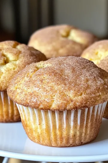 - 1 ½ cups all-purpose flour - 1 teaspoon baking powder - ½ teaspoon baking soda - ½ teaspoon salt - 1 teaspoon ground cinnamon - ½ cup unsalted butter, softened - 1 cup granulated sugar - 2 large eggs - 1 teaspoon vanilla extract - ¾ cup buttermilk - ½ cup cinnamon sugar (¼ cup granulated sugar + 1 tablespoon ground cinnamon) Gathering the right ingredients is key. I love using high-quality flour for the best texture. The baking powder and baking soda work together to make the muffins rise. Salt and cinnamon add flavor, too. For the wet mix, I prefer unsalted butter. It gives you control over the saltiness. Granulated sugar adds sweetness and helps with the muffin's texture. Eggs bind everything together. I always use fresh eggs for their richness. Vanilla adds a nice touch, and buttermilk keeps the muffins moist. For the topping, the cinnamon sugar is a must. It gives the muffins a sweet, crunchy finish. You can adjust the sugar and cinnamon to your taste. The balance of flavors makes these muffins a delight. - Preheat the oven to 350°F (175°C). - Line or grease the muffin tin. Start by preheating your oven. This step ensures even baking. Greasing or lining the muffin tin helps muffins come out easily. - Whisk the dry ingredients together. - Cream the butter and sugar. - Add eggs and vanilla to the mixture. In a bowl, whisk together the flour, baking powder, baking soda, salt, and cinnamon. This mix adds flavor and structure. In another bowl, beat the softened butter with sugar until it’s light and fluffy. This process creates air, making the muffins rise. Next, add the eggs one at a time and mix well. Finally, stir in the vanilla extract for that warm flavor. - Alternate adding dry ingredients and buttermilk. - Fill muffin tins with batter. Now it's time to combine everything. Gradually add the dry mixture and buttermilk to the butter mix, starting and finishing with the dry mix. Remember, mix gently to avoid tough muffins. Once mixed, scoop the batter into the muffin tins, filling each about two-thirds full. - Prepare the cinnamon sugar topping. - Bake and check for doneness. For the topping, mix sugar and cinnamon in a small bowl. Sprinkle it generously over the muffins before baking. Now, place the muffin tin in the oven. Bake for 18-20 minutes. To check if they are done, insert a toothpick in the center. It should come out clean. - Cool muffins in the pan. - Transfer to a wire rack. After baking, let the muffins cool in the pan for 5 minutes. This helps them firm up. Then, carefully transfer them to a wire rack to cool completely. Enjoy the delightful aroma as they cool! To make your snickerdoodle muffins fluffy, cream the butter and sugar well. I use an electric mixer for this step. Mix them for about 3 to 4 minutes. You want the mixture to be light and fluffy. This adds air to your muffins. Be careful not to overmix the batter when you combine wet and dry ingredients. Mix until you see no dry flour. Overmixing can make your muffins tough. Gently folding in the ingredients keeps them soft and airy. You can serve these muffins warm or at room temperature. They taste great either way. I like to arrange them on a rustic wooden platter. For a special touch, sprinkle extra cinnamon sugar on top just before serving. This adds a nice crunch and sweetness. Here are some essential tools for this recipe: - Electric mixer for creaming butter and sugar - Muffin tin, preferably a non-stick type - Mixing bowls for dry and wet ingredients - Whisk for combining dry ingredients Using a quality muffin tin helps your muffins bake evenly. A non-stick tin makes it easy to remove muffins without any mess. {{image_2}} You can easily change the flavor of your snickerdoodle muffins. Try adding chocolate chips or nuts for a sweet crunch. They add a rich texture that complements the cinnamon well. If you love fruit, mix in some diced apples or mashed bananas. These fruits add moisture and a hint of natural sweetness. You can even use dried fruits like raisins or cranberries for an extra twist. If you need a gluten-free version, use alternative flours like almond or coconut flour. These flours can change the texture, so experiment to find what you like best. For a vegan option, substitute butter with coconut oil and use flax eggs instead of regular eggs. Mix 1 tablespoon of flaxseed meal with 3 tablespoons of water for one egg. This will keep your muffins moist and delicious. You can get creative with the toppings too. Instead of the standard cinnamon sugar, try a streusel topping. Mix flour, sugar, and butter for a crumbly texture. It adds a nice crunch on top. Another fun option is to use flavored sugars, like maple or hazelnut. These sugars can give your muffins a unique taste that surprises your guests. To keep your muffins fresh, store them in an airtight container. This helps them stay soft and moist. Place them at room temperature if you plan to eat them within a few days. They will last about 2 to 3 days this way. If you want to keep them longer, refrigerate them. In the fridge, they can last up to a week. Just remember, cold air can dry them out, so keep them sealed tight. Freezing muffins is a great way to save them for later. To freeze, first, let the muffins cool completely. Then wrap each muffin in plastic wrap. After that, place them in a freezer-safe bag or container. This will keep them fresh for about 2 to 3 months. When you want to enjoy one, take it out and let it thaw at room temperature. You can also warm it up in the microwave for a few seconds. This helps keep the texture nice and soft. The secret to fluffy muffins lies in two key steps: using the right ingredients and mixing them correctly. - Use room temperature butter: This helps the butter cream better with sugar. - Cream well: Mix the butter and sugar until it’s light and fluffy. This takes about 3-4 minutes. - Do not overmix: When adding flour, mix until just combined. Overmixing makes the muffins dense. These steps help create air pockets, leading to a light and fluffy texture. To keep your muffins moist, focus on two important factors: buttermilk and fat content. - Buttermilk: It adds moisture and a slight tang. It helps break down gluten, making muffins softer. - Fat content: The unsalted butter also contributes to moisture. It adds richness to the muffins. Both ingredients are key to achieving that perfect moist muffin. Yes, you can use regular milk. However, you need to make a small change. - Add acid: Mix ¾ cup of regular milk with 1 tablespoon of lemon juice or vinegar. Let it sit for 5 minutes. This will mimic buttermilk’s tang and acidity. - Adjust baking powder: Using regular milk means you may need to adjust the baking powder slightly, but usually, it works well. This option helps you achieve a similar texture and flavor. Snickerdoodle muffins can last a good while when stored properly. - Room temperature: They stay fresh for about 2-3 days. Keep them in an airtight container. - Refrigerator: If you store them in the fridge, they can last up to a week. For longer storage, consider freezing. This helps maintain freshness for up to three months. You now have a simple guide to baking delicious snickerdoodle muffins. We covered the key ingredients, step-by-step instructions, and helpful tips. Remember to cream the butter and sugar well for fluffy muffins. Try out different flavors and toppings to make them your own. Proper storage keeps them fresh for longer. Enjoy these tasty treats straight from the oven or at room temperature. You have all the tools to succeed. Get ready to impress your friends and family with your baking skills!